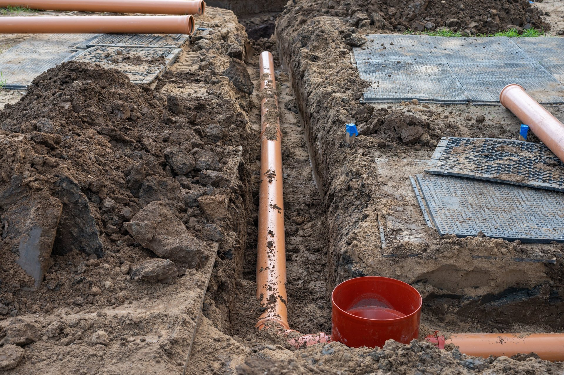 Instalación de tubería de drenaje en zanja en obra de construcción residencial